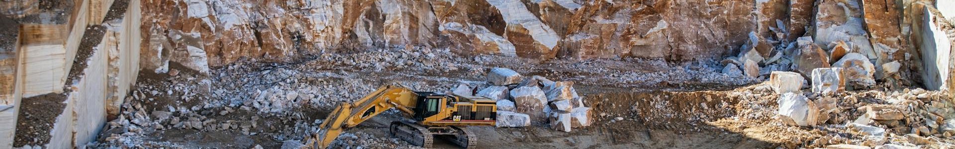 Open-pit stone quarry with excavator showing the scale and complexity of mining sites surveyed by UAV drones